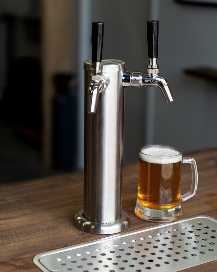 A glass of beer beside a bar tap